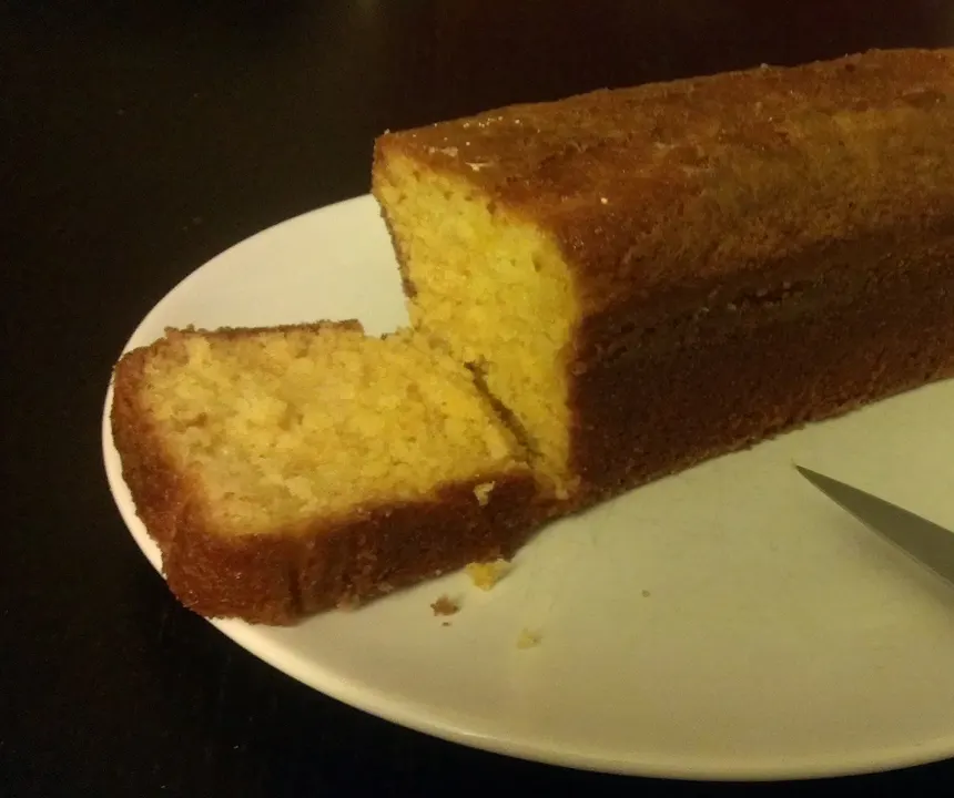 Cake au citron entamé, une tranche coupée et un couteau à côté